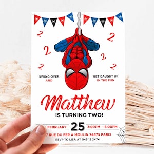 Puede incluir: Una invitaci&oacute;n de cumplea&ntilde;os de Spiderman roja y azul con un dibujo animado de Spiderman colgando boca abajo. La invitaci&oacute;n dice "&iexcl;Matthew cumple dos a&ntilde;os!" e incluye la fecha, la hora y el lugar de la fiesta.