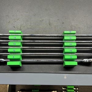 May include: A set of six chrome ratcheting wrenches, each held in place by a bright green holder. The wrenches are labeled with numbers from 8 to 19. The tools are arranged neatly on a dark surface.