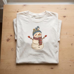 Winter Snowman clipart design printed on a shirt, as an example