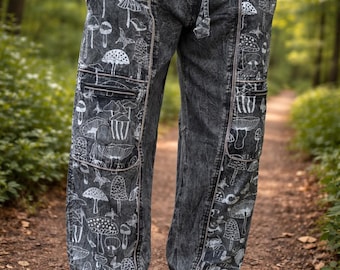 May include: Dark grey trousers with a white mushroom pattern. The trousers have a drawstring waist, pockets, and are cuffed at the ankles. The person in the image is wearing brown shoes.