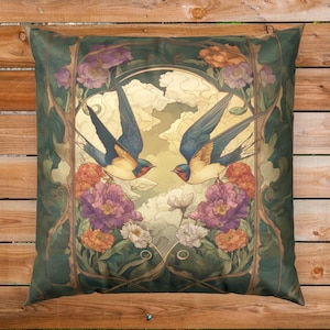May include: Square decorative pillow featuring a vintage-style illustration of two swallows in flight, set against a backdrop of clouds and flowers. The pillow has a dark green border with floral and vine motifs, and the swallows have blue wings and orange accents.