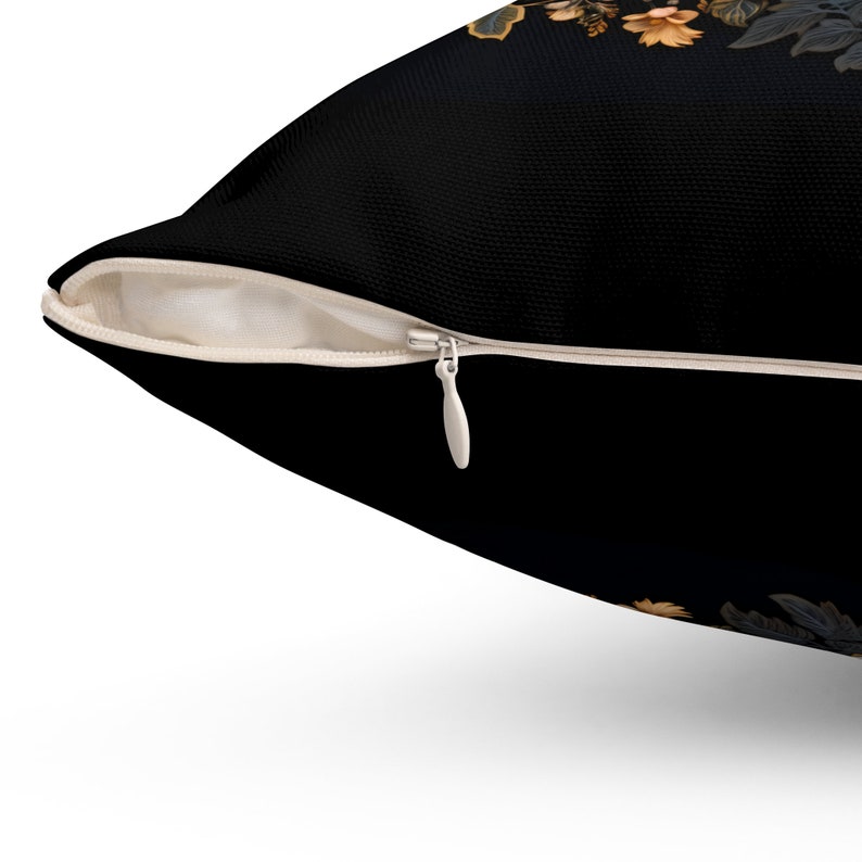 Puede incluir: Una almohada negra con cierre de cremallera. La almohada tiene un patr&oacute;n floral en tonos naranja y marr&oacute;n.