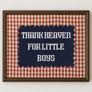 May include: Framed artwork with a dark brown frame. The background is a red and white gingham pattern. A navy blue stitched fabric with the words "THANK HEAVEN FOR LITTLE BOYS" in white is centered in the frame.