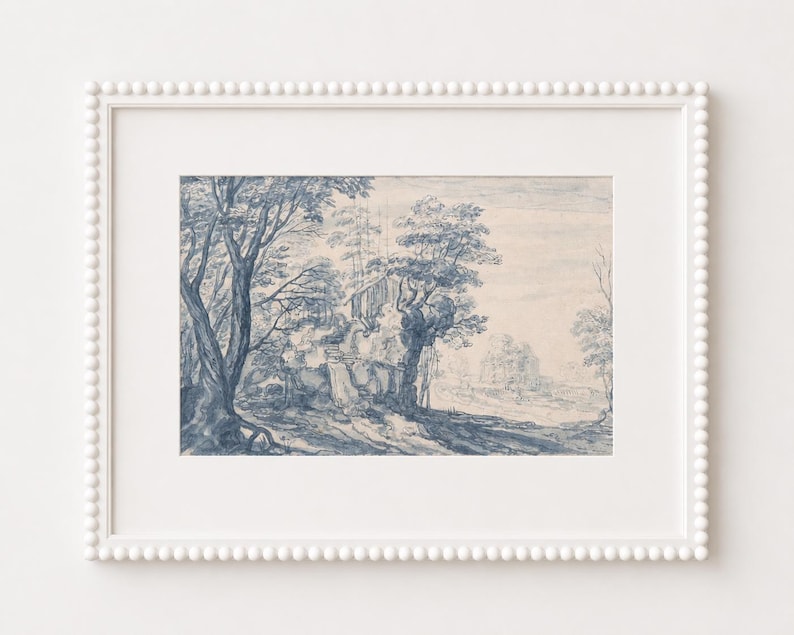 May include: A framed landscape art print featuring a detailed blue and white illustration of trees, a building, and a path. The artwork is set in a white frame with a beaded edge, creating a classic aesthetic.