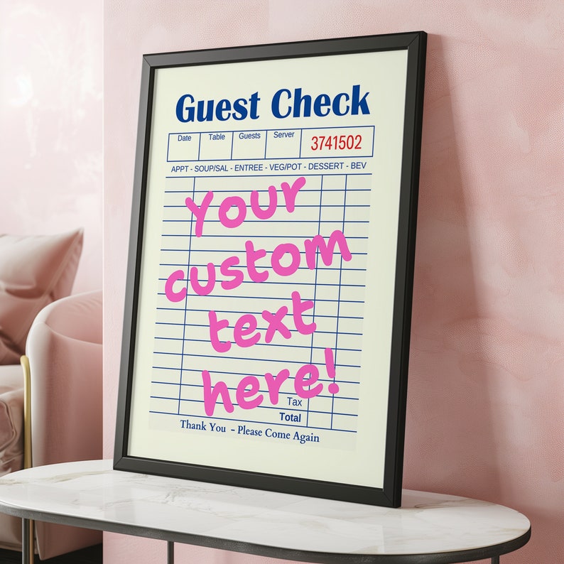 May include: A black framed print with a white background and blue lines. The text "Guest Check" is in blue at the top of the print. The text "Your custom text here!" is in pink and is centered on the print. The text "Date, Table, Guests, Server" is in blue at the top of the print. The number "3741502" is in red at the top of the print. The text "APPT-SOUP/SAL ENTREE-VEG/POT-DESSERT-BEV" is in blue at the top of the print. The text "Tax Total" is in blue at the bottom of the print. The text "Thank You - Please Come Again" is in blue at the bottom of the print.