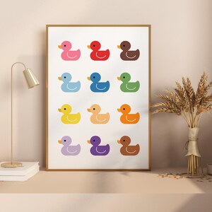 May include: A printable wall art design featuring a grid of 12 colorful rubber duckies. The ducks are arranged in a rainbow pattern, with each duck a different color.