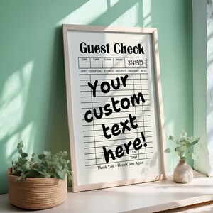 May include: A white framed sign with the text "Guest Check" and a blank check list with the text "Your custom text here!" printed on it. The sign is sitting on a white surface.