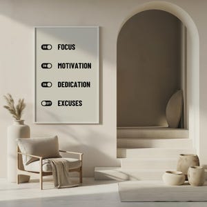 May include: A white framed print with black text that reads "ON FOCUS", "ON MOTIVATION", "ON DEDICATION", and "OFF EXCUSES". The print is hanging on a white wall in a modern interior with a chair, a plant, and a set of stairs.