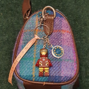 May include: A white ceramic mug with a black handle and the text "But First, Coffee" in a black, handwritten-style font. The mug is on a white surface.