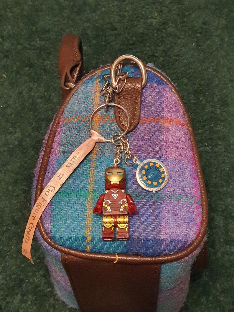 May include: A white ceramic mug with a black handle and the text "But First, Coffee" in a black, handwritten-style font. The mug is on a white surface.