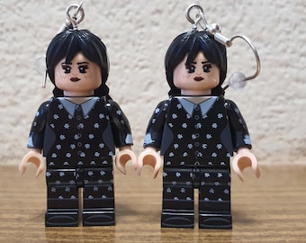 Może przedstawiać: Dwie minifigurki Lego w czarno-białe wzory, z czarnymi włosami i białymi kolczykami. Minifigurki noszą czarne koszule w białe kropki i czarne spodnie w białe kropki.