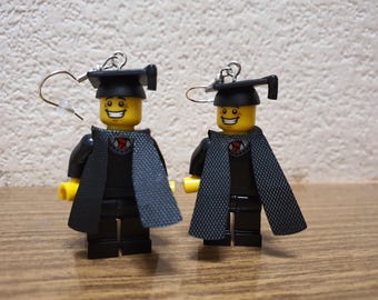 Orecchini a forma di minifigure di laureato.