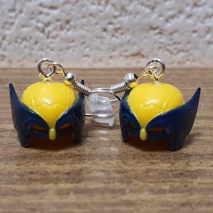 May include: A pair of silver earrings with yellow and blue Wolverine character charms.