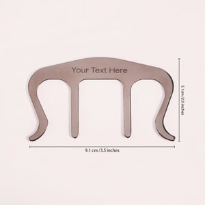 Peut inclure: Un clip &agrave; cheveux en plastique gris avec trois dents. Le clip mesure 9,1 cm / 3,5 pouces de large et 5,1 cm / 2,0 pouces de haut. Le texte "Your Text Here" est grav&eacute; sur le dessus du clip.