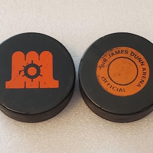 2 Game Used 1970s Hockey Pucks: Maine Mariners AHL, Sir James Dunn Hockey School