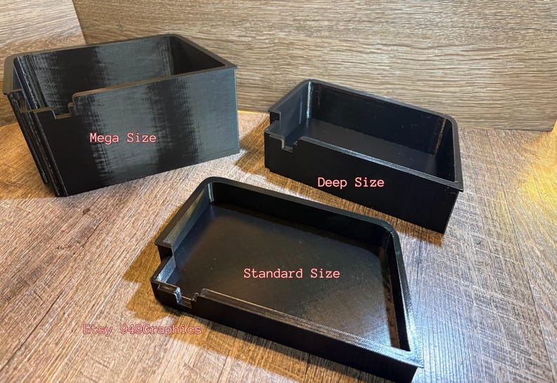 K&ouml;nnte beinhalten: Drei schwarze Aufbewahrungsbeh&auml;lter unterschiedlicher Gr&ouml;&szlig;e werden auf einer Holzoberfl&auml;che gezeigt. Die Beh&auml;lter sind mit "Mega Size", "Deep Size" und "Standard Size" beschriftet. Die Beh&auml;lter sind rechteckig und haben eine strukturierte Oberfl&auml;che.