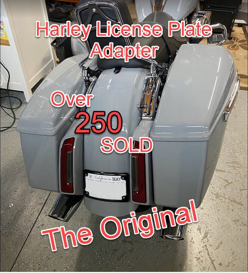 Peut inclure: Une moto Harley Davidson grise avec des sacoches et un adaptateur de plaque d'immatriculation. Le texte sur l'image indique "Harley License Plate Adapter", "Over 250 SOLD" et "The Original".