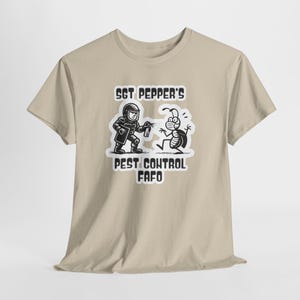 May include: Beige t-shirt featuring a black and white graphic of a pest control worker spraying a bug. The text on the shirt reads "Sgt Pepper's Pest Control FAFO."