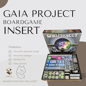 Op de afbeelding: Een zwarte en grijze bordspel insert voor het bordspel Gaia Project. De insert heeft compartimenten voor alle spelonderdelen, inclusief het bord, kaarten en tokens. De insert is gemaakt in Duitsland en is ontworpen om gesleevde kaarten te passen. De insert wordt getoond met de speldoos open, waardoor de insert en de spelonderdelen zichtbaar zijn.