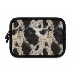 May include: A black laptop sleeve with a zipper closure. The sleeve features a brown and white animal print pattern.