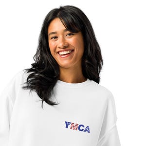 May include: A white sweatshirt with a blue and red YMCA logo on the front. The logo features a red and white American flag design.