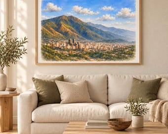 May include: A framed landscape wall art print featuring a sprawling city nestled at the base of a massive, sunlit mountain range under a bright blue sky with scattered white clouds. The scene captures a dense urban skyline with tall buildings.