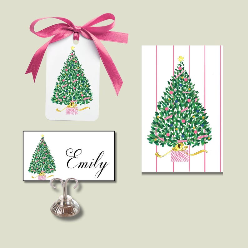 May include: Christmas-themed stationery set featuring a green Christmas tree design with pink and gold accents. Includes a gift tag with a pink ribbon, a place card with the name "Emily", and a card with pink stripes.