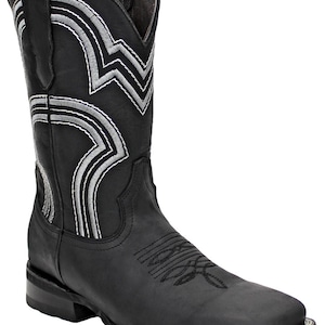 May include: Black leather cowboy boot with silver and white decorative stitching. The boot features a square toe and a stacked heel. The shaft has a decorative pattern with silver stitching. A classic Western-style boot.