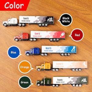 May include: A set of toy semi-trucks with different coloured trailers. Each trailer has a company name and logo. The colours are black and white, red, blue, orange, and green.