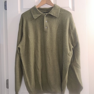 May include: A green long-sleeved collared sweater with a button closure.
