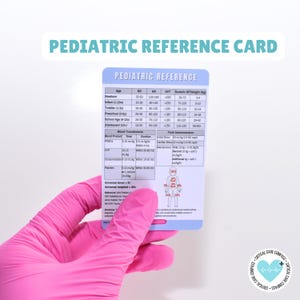 May include: A rectangular paediatric reference card with a light blue border and white background. The card features a table with medical data including age, respiratory rate, heart rate, and blood pressure, plus sections for blood transfusions and fluid administration.