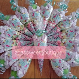 May include: A collection of clear plastic cones filled with pastel-coloured sweets and marshmallows. Each cone has a small round sticker with a fairy illustration and the text "Thank you for coming to my party".