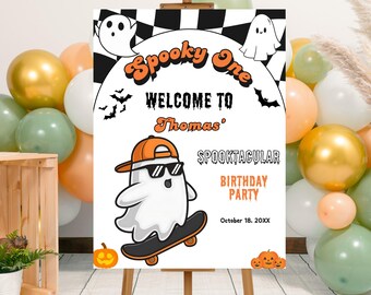 May include: A Halloween-themed sign on an easel, featuring the text "Spooky One" and "Welcome to Thomas' Spooktacular Birthday Party." The sign includes illustrations of ghosts, bats, and pumpkins. Balloons in gold, white, orange, and green surround the sign.