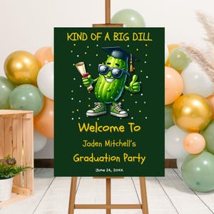 Peut inclure: Panneau de fête de remise de diplôme avec un cornichon de dessin animé portant une toque et des lunettes de soleil. Le panneau indique "KIND OF A BIG DILL" et "Welcome To Jaden Mitchell's Graduation Party" avec la date du 24 juin 20XX. Le panneau est sur un chevalet.
