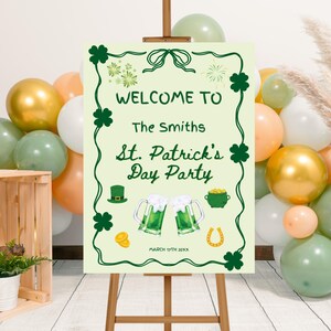 以下が含まれることがあります： イーゼルに立てられた、緑のクローバーと「Welcome to The Smiths St. Patrick's Day Party」の文字が入った、聖パトリックの日のパーティーのウェルカムサイン。ビールジョッキ、金のポット、蹄鉄の画像が含まれています。