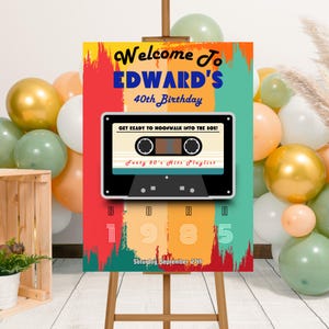 Puede incluir: Un cartel de bienvenida para una fiesta de cumpleaños número 40 con un diseño de casete retro. El cartel está decorado con pinceladas coloridas y el texto "Bienvenido a Edward's 40 cumpleaños. ¡Prepárate para hacer moonwalk en los 80! Lista de reproducción de los 40 éxitos de los 80. Nacido en 1985. Sábado 27 de septiembre."