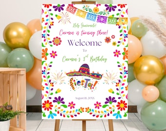 Puede incluir: Un colorido letrero de bienvenida para una fiesta de cumpleaños sobre un caballete. El letrero dice "Holy Guacamole! Carmen cumple tres años! ¡Bienvenida al 3er cumpleaños de Carmen!" con un sombrero y la palabra "Fiesta!" en el centro. El letrero está decorado con flores y fuegos artificiales.