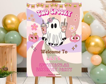 May include: A Halloween-themed party sign on a wooden easel. The sign features a cartoon ghost holding drinks, with the text "Two Spooky" and "Welcome to Lily's Spooktacular Birthday Party." The color scheme includes pink, purple, and orange.