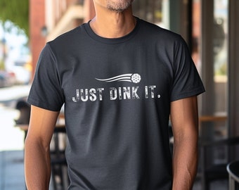May include: A black t-shirt with a white graphic of a ball with a trail behind it and the text "JUST DINK IT."