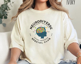 May include: A white t-shirt with a graphic of a blue silhouette of a person with a puzzle piece brain. The graphic says "Neurodiverse - Different - Beautiful" and "Autism Awareness Special Club".