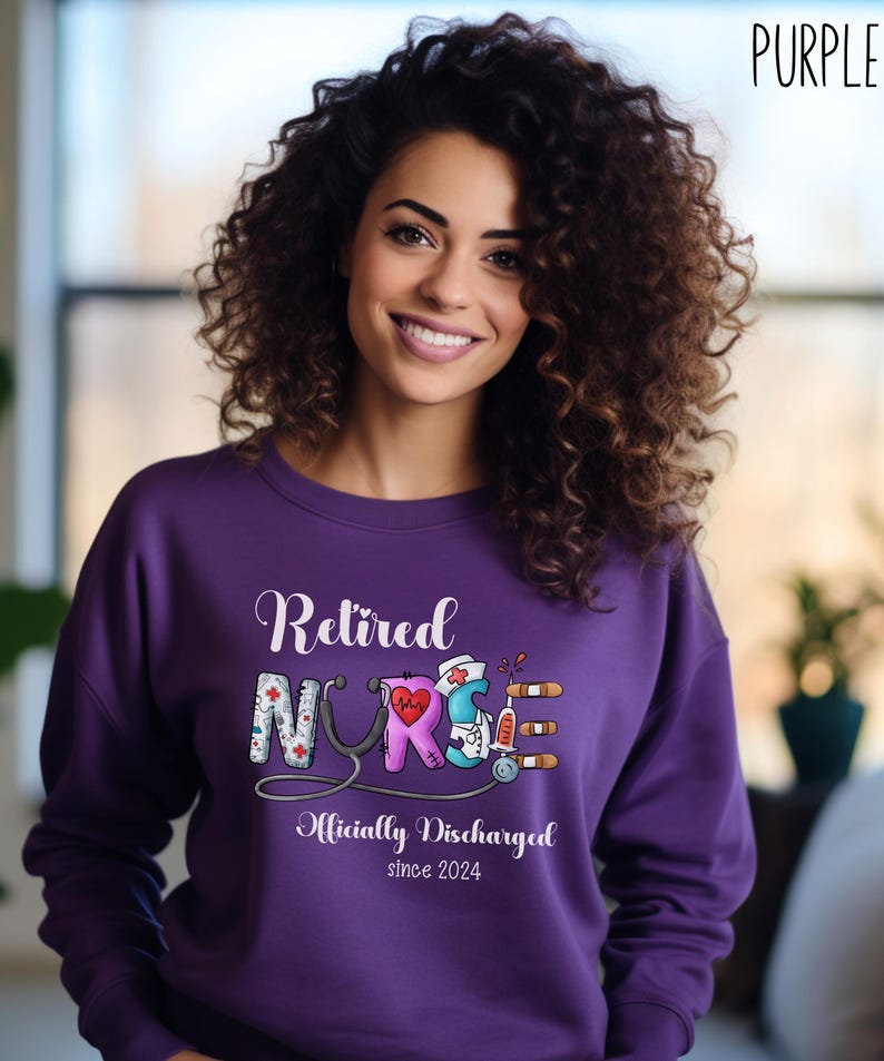 May include: Purple sweatshirt with the text "Retired Nurse Officially Discharged since 2024" and a graphic of a stethoscope and medical symbols.