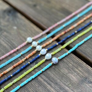 May include: A set of six necklaces with different colored beads and a pearl accent. The necklaces are made with turquoise, green, blue, orange, pink, and white beads.