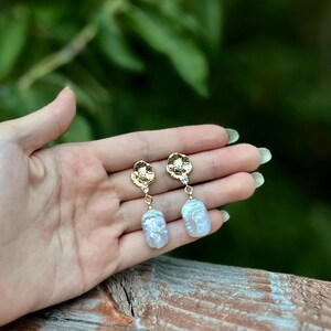 Puede incluir: Pendientes de gota de oro y perla blanca. Los pendientes presentan un disco de oro texturizado con un peque&ntilde;o acento de perla blanca y una gran perla barroca blanca.