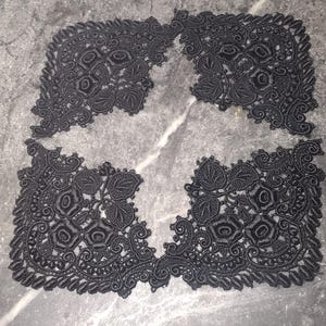May include: Four black lace appliqués featuring intricate floral and leaf embroidery with scalloped edges. Each piece displays a symmetrical arrangement of roses and foliage, crafted with detailed threadwork and a dense, textured pattern.