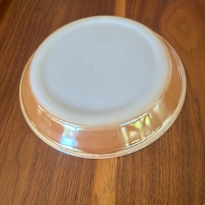 May include: A white ceramic plate with a brown rim. The plate has a smooth, glossy finish.