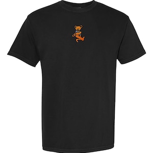 May include: Black t-shirt with a small embroidered image of a brown bear with a blue bandana.