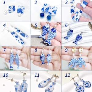 Puede incluir: Una colección de doce pares de pendientes con patrones de estilo porcelana azul y blanca. Los diseños incluyen colgantes cuadrados, rectangulares y con forma de pez, algunos acentuados con pequeñas perlas blancas o metal dorado.