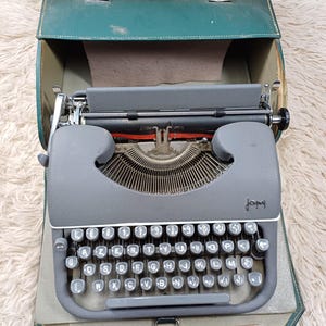 Vintage Japy typewriter with green hard cover – good condition