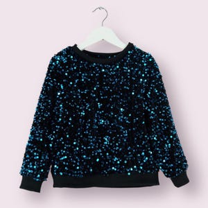 May include: A black long-sleeved sweater covered in teal sequins.