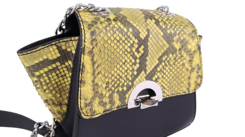 May include: A black and yellow snakeskin-patterned crossbody bag with a silver chain strap. The bag features a flap closure with a silver clasp. The bag's design includes a combination of black and yellow tones, creating a striking contrast.